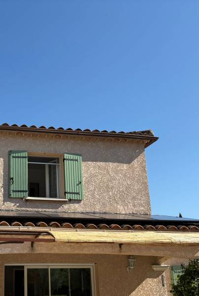 Panneaux photovoltaïques inclinés sur toiture plate d’une villa moderne à Monteux